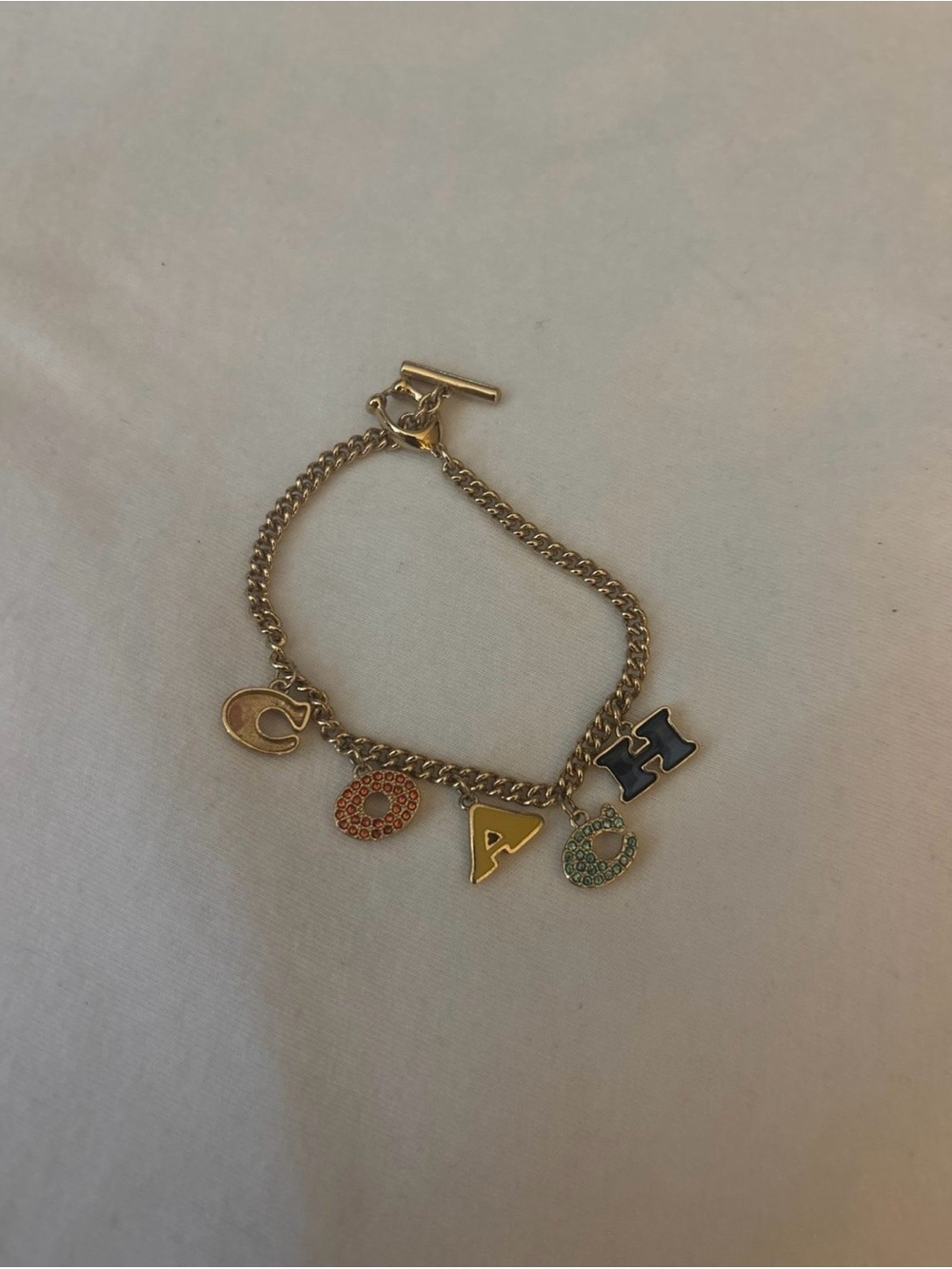 Coach Gold Tone Bracelet with Multicolor Letter and Charm Accents